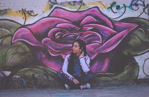 girl sitting near the wall with graffiti