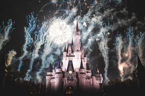 Disney Land castle in light, among the colorful fireworks, at the night