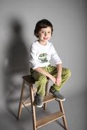little boy posing on chair in studio