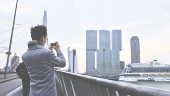 young man takes pictures on the phone port in Hamburg