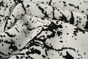 Close-up of the white and black fabric with patterns, with folds