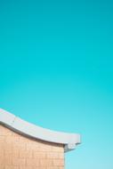 Corner of the brick building, at beautiful, turquoise sky on background