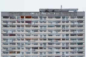 Grey building with colorful windows, under the sky