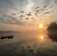 the sun shines by the lake in the evening