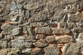 Close-up of the colorful, old stone wall in light