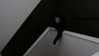 Man in black jacket, walking down the stairs
