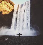 man near a large waterfall