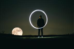 Person with the beautiful, white light circle, at background with Moon