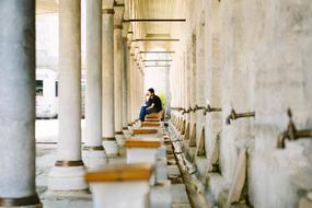 Man Alone sitting, waiting on bench