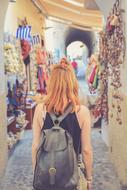 Back view of the girl, with the bag, waking among the colorful and beautiful walls