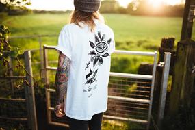 Man with tattoo on hand in countryside
