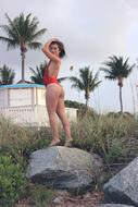 girl in a red swimsuit posing on a stone