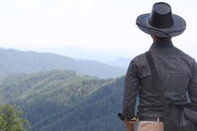 back view of man in black clothing at scenic landscape