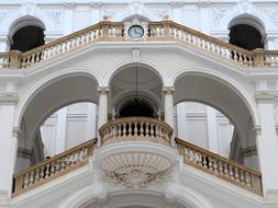 white Edifice with clock, staircases and balconies