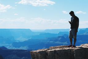 guy on the edge of a cliff in a canyon