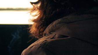 man with long hair close up on blurred background