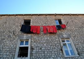 red and black clothing on line at Brick wall