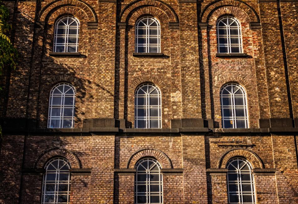 Beautiful facade of the brick house with the windows, in light and shadow