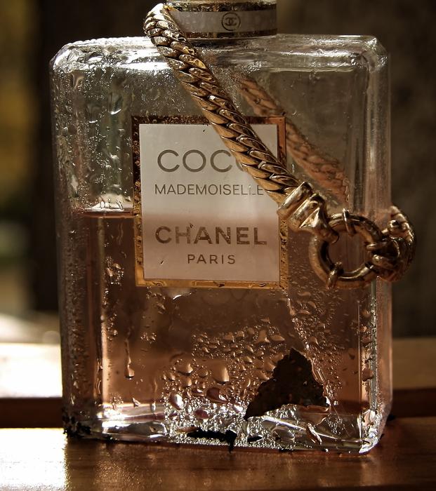 Gold bracelet on a can of perfume