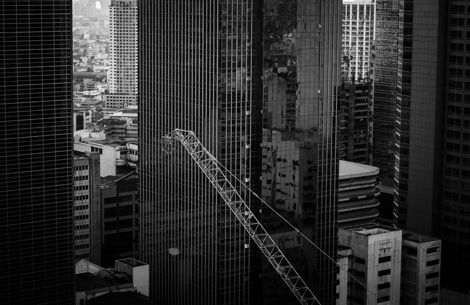 construction crane boom at skyscrapers in downtown