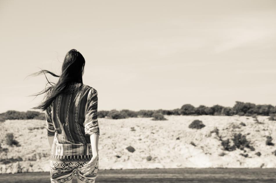 Retro photo with the back of the girl, walking near the hills with the plants