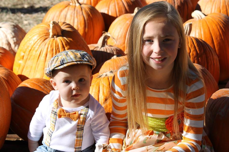 Children near pumpkins at fall
