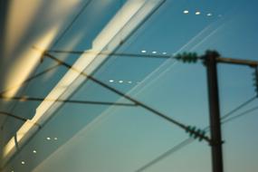 Electricity cables, under the beautiful and colorful sky, on the view through the glass