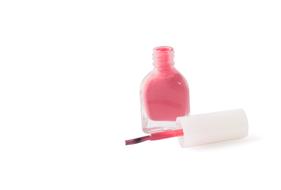 Pink varnish in the shiny glass, at white background