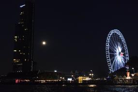 Cityscape with the colorful lights and Ferris wheel, at the night