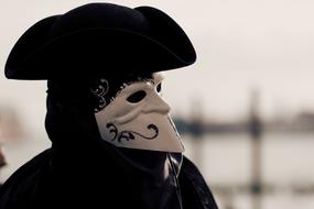 photo of a man wearing a carnival mask and costume in Venice