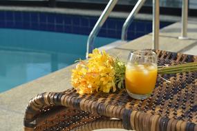 Orange juice on the table by the pool