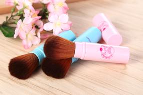 Colorful make-up brushes, near the colorful and beautiful flowers, on the wooden surface