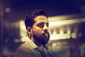 bearded man in dark blurred background