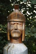 Beautiful old wooden statue of Legionnaire with helmet near the green trees