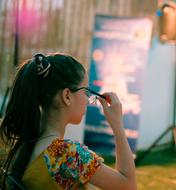 young girl taking off glasses