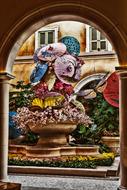 Colorful decoration with flowers among the buildings, on the view from the arch