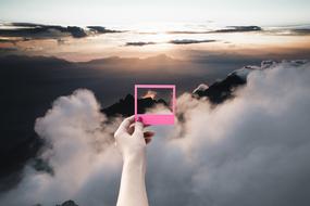 collage against the sky with a human hand