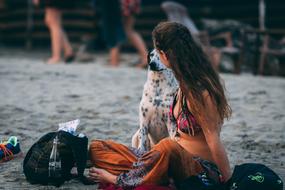 girl and dog sitting on beach