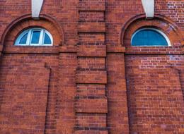 Red brick wall of different shades, with window eyes