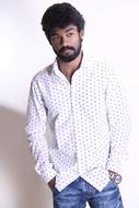 a man with a beard in a white polka dot shirt