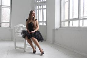 Girl in black dress posing in White Hall