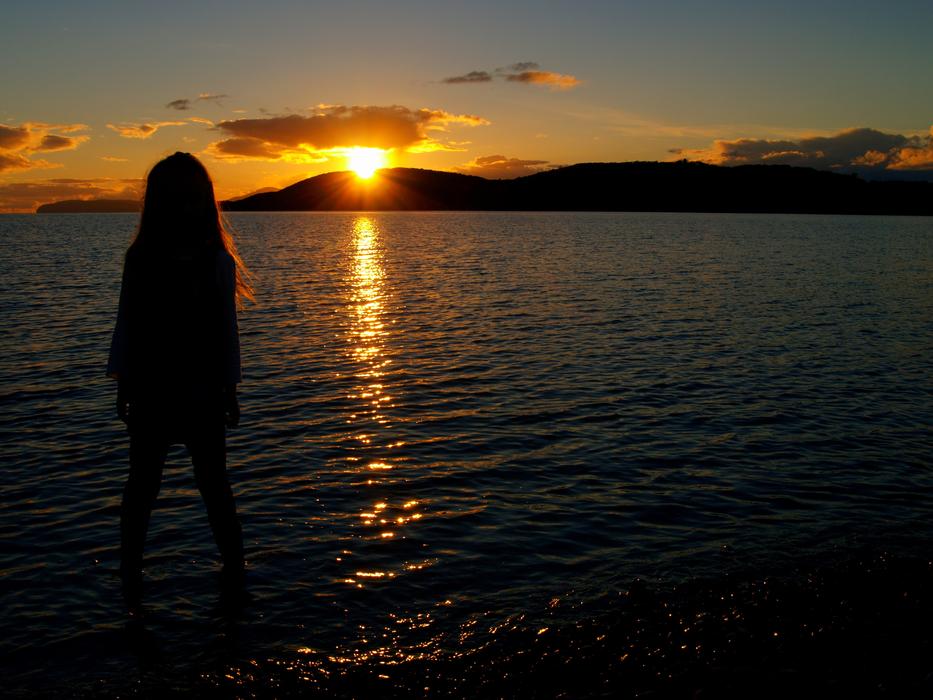 girl silhouette at Sunset by Water