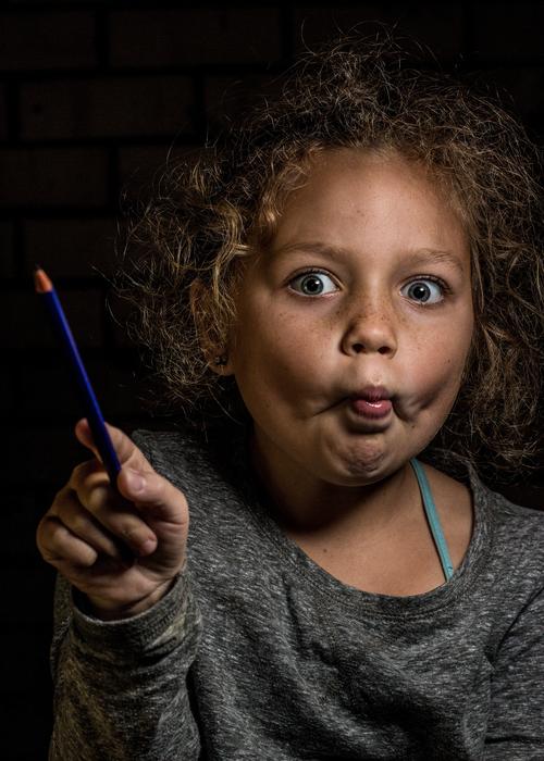 playful girl with pencil in hand