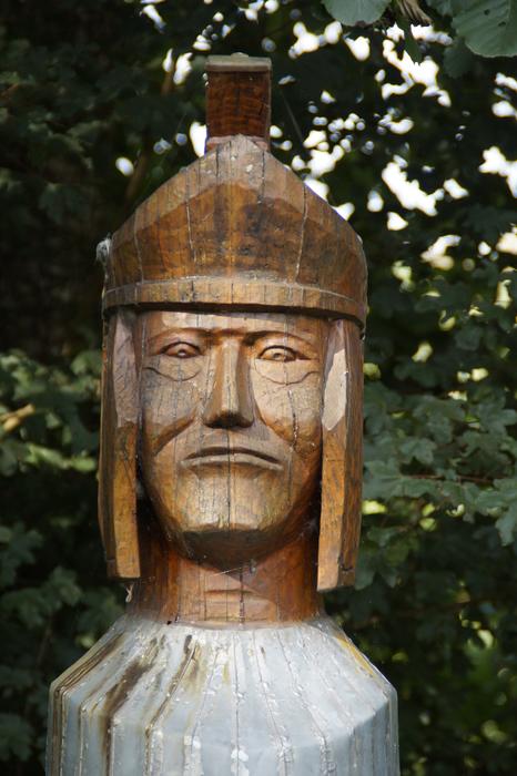 Beautiful old wooden statue of Legionnaire with helmet near the green trees
