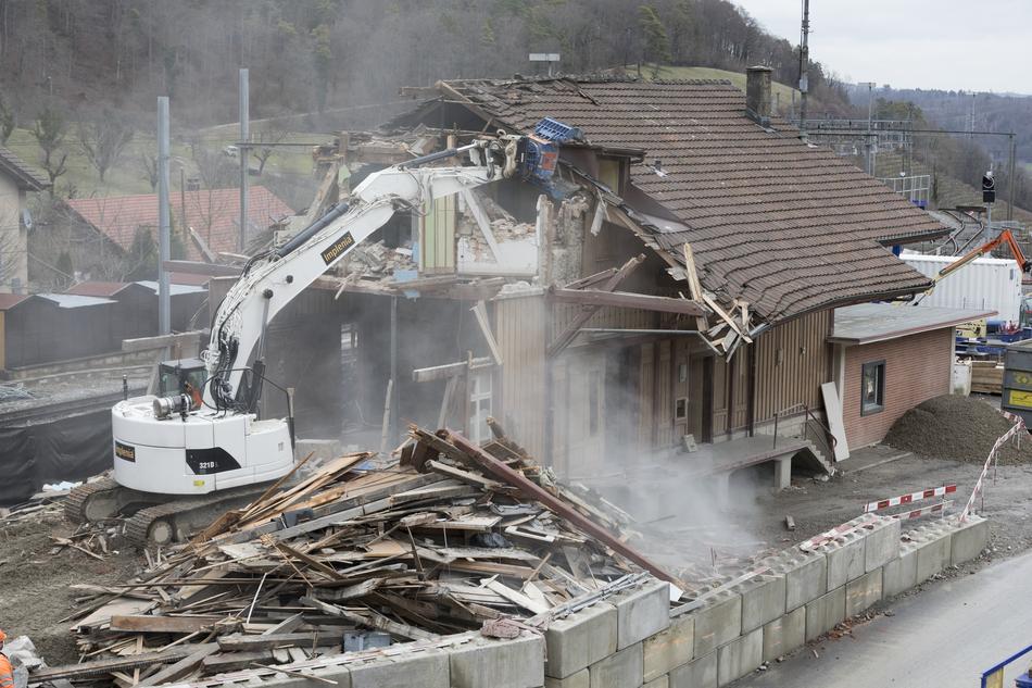 Crashing building with excavators, near the mountains