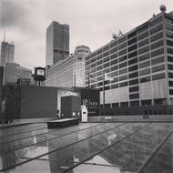 Black and white photo of the city downtown with shiny buildings