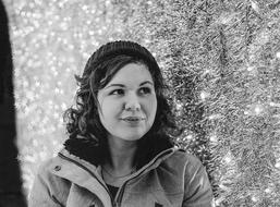 black and white photo of a girl near christmas lights