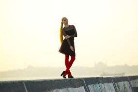 long haired girl in Red tights posing at foggy city