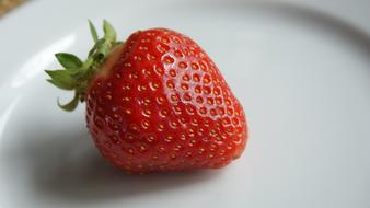 single strawberry on a plate