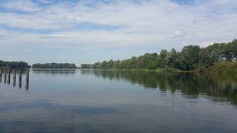 a large lake with a bridge by the forest